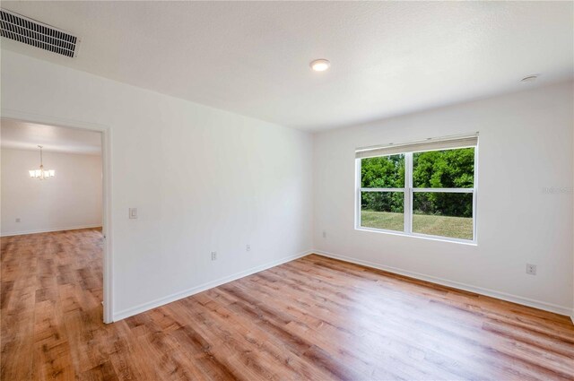 2950 Gibraltar Blvd, New Smyrna Beach, FL 32168 - unfurnished room featuring baseboards, light wood finished floors, a chandelier, and visible vents