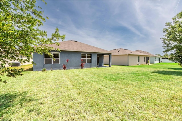 2950 Gibraltar Blvd, New Smyrna Beach, FL 32168 - rear view of house featuring stucco siding and a yard