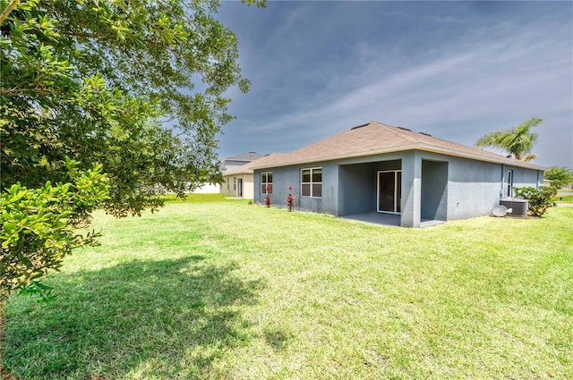 2950 Gibraltar Blvd, New Smyrna Beach, FL 32168 - back of property with a lawn, central air condition unit, and stucco siding