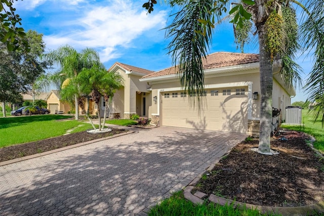 mediterranean / spanish home with central air condition unit, a garage, and a front lawn