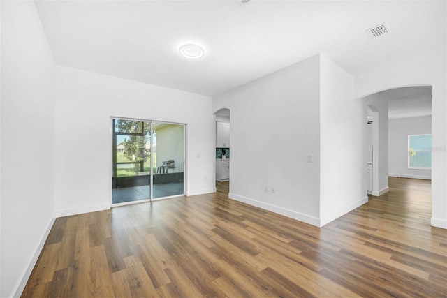 unfurnished room with dark wood-type flooring