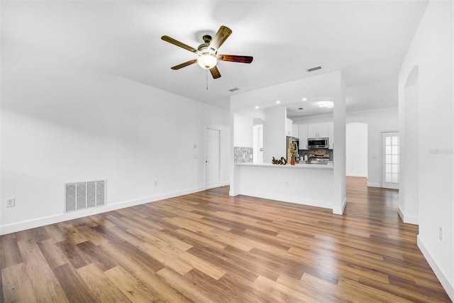 unfurnished living room featuring ceiling fan and light hardwood / wood-style flooring