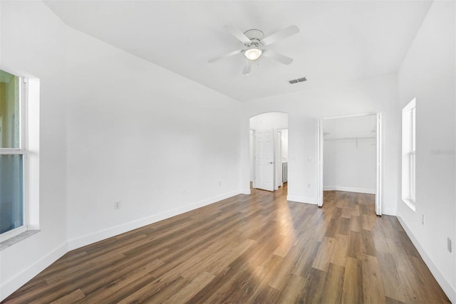 unfurnished bedroom featuring dark hardwood / wood-style flooring, a spacious closet, ceiling fan, and a closet