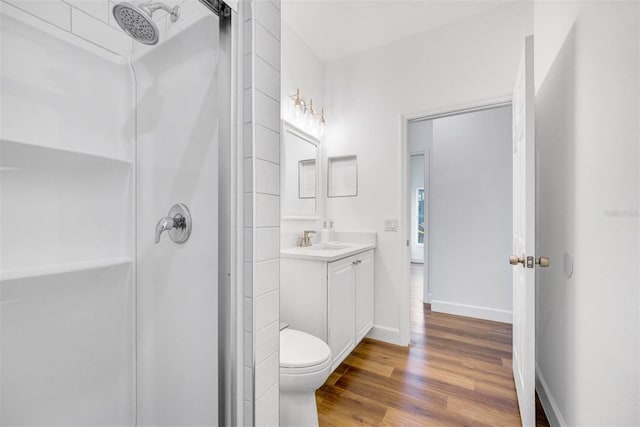 bathroom with hardwood / wood-style flooring, vanity, toilet, and walk in shower