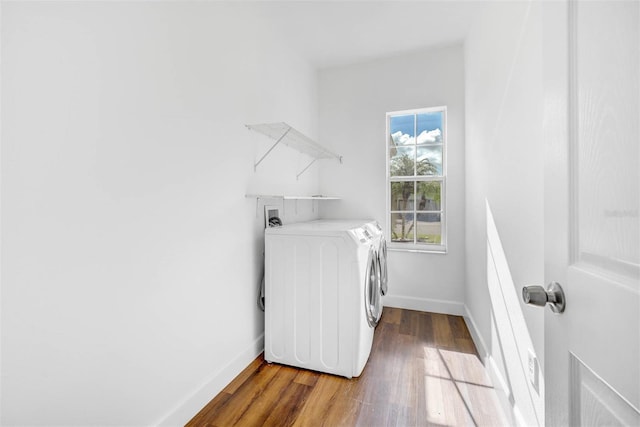 clothes washing area featuring wood-type flooring and separate washer and dryer