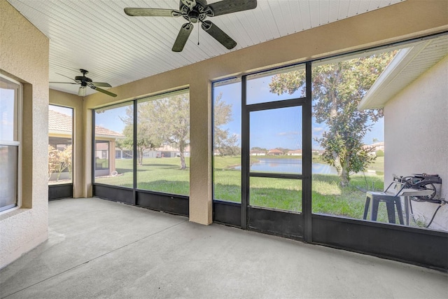 sunroom / solarium featuring a water view and ceiling fan