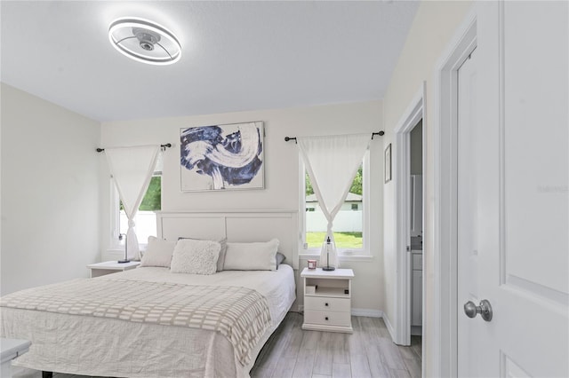 bedroom featuring multiple windows and light hardwood / wood-style floors