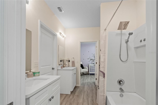 bathroom featuring vanity, wood-type flooring, and  shower combination