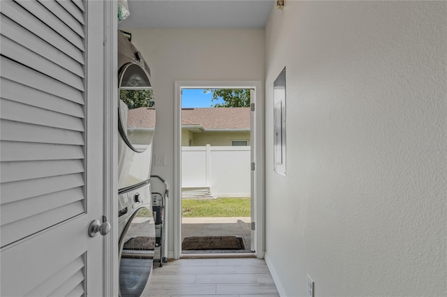 entryway featuring stacked washer / dryer and a wealth of natural light