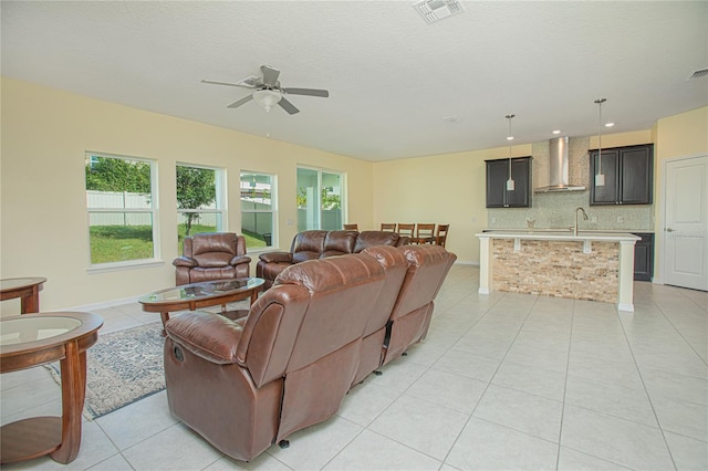 living room featuring light tile patterned flooring, a textured ceiling, and ceiling fan