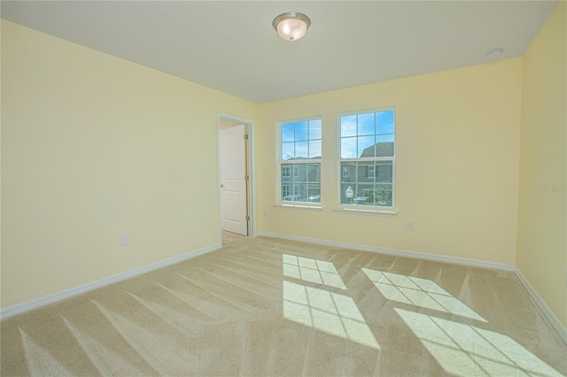 unfurnished room featuring light carpet