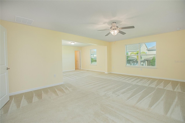 spare room featuring light colored carpet and ceiling fan