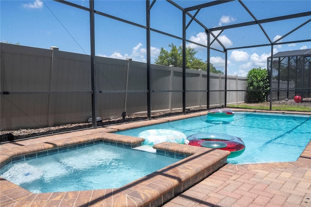 view of swimming pool with an in ground hot tub and a lanai