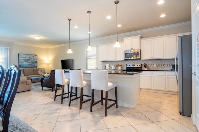 kitchen featuring white cabinetry, tasteful backsplash, hanging light fixtures, ornamental molding, and appliances with stainless steel finishes