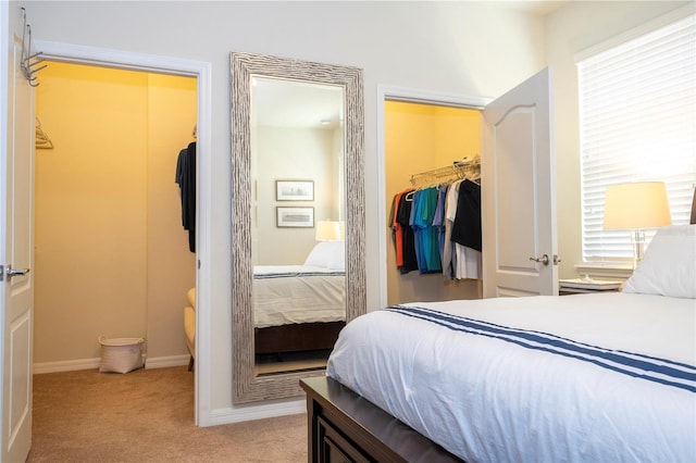 bedroom featuring a spacious closet, light carpet, and a closet