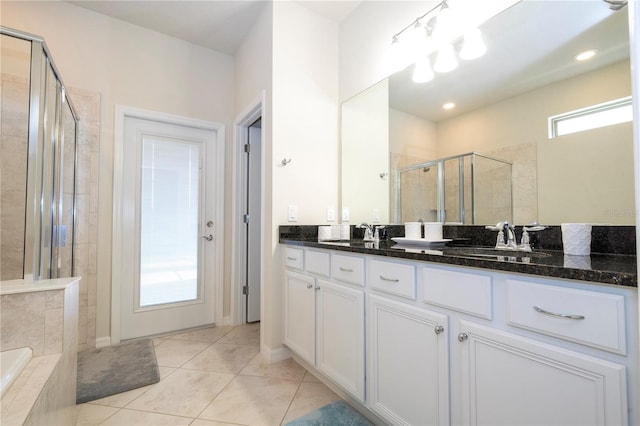 bathroom featuring tile patterned flooring, double sink vanity, and plus walk in shower