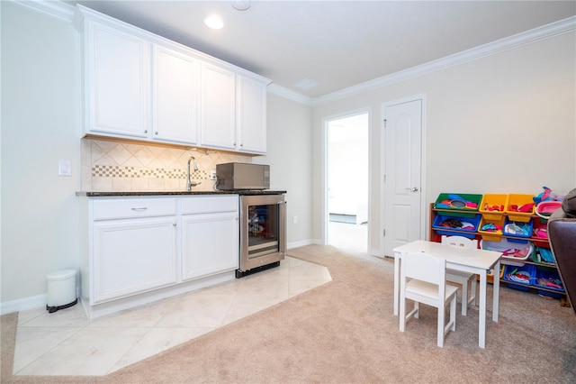 kitchen with ornamental molding, light tile patterned flooring, tasteful backsplash, and beverage cooler