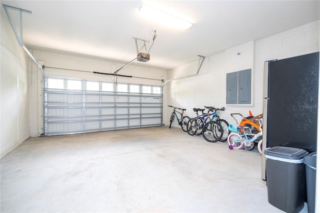 garage featuring a garage door opener, fridge, and electric panel