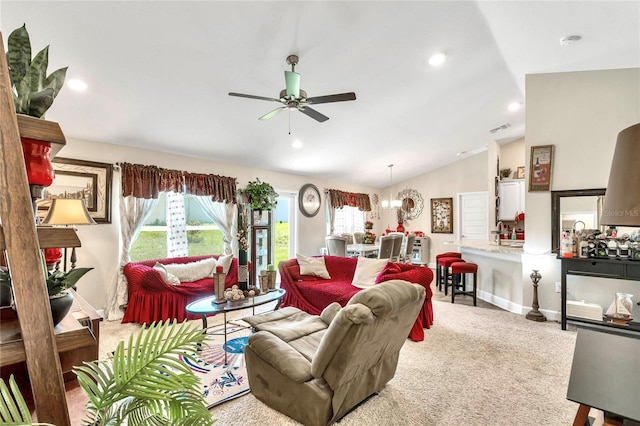 carpeted living room featuring ceiling fan with notable chandelier and lofted ceiling