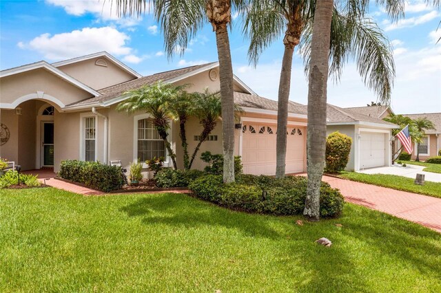 single story home featuring a garage and a front yard