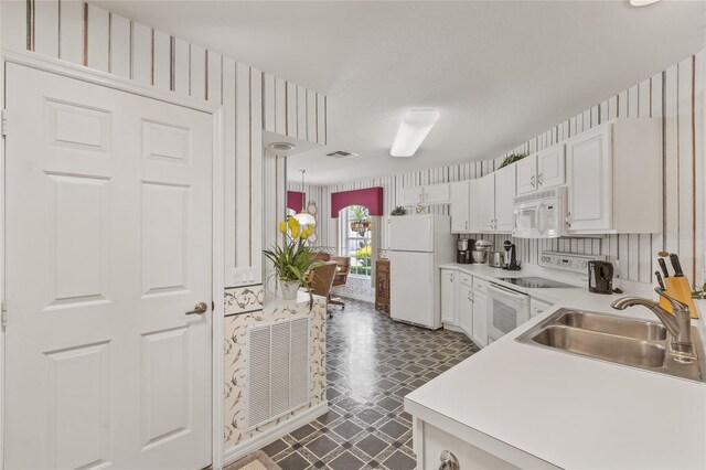 kitchen featuring sink, dark tile patterned floors, white appliances, and white cabinetry