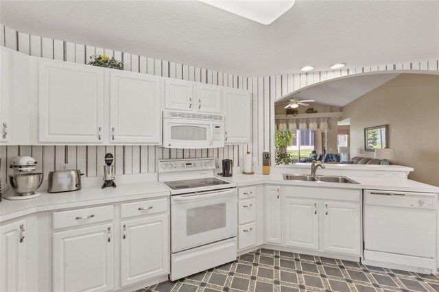 kitchen with ceiling fan, white cabinets, white appliances, sink, and vaulted ceiling