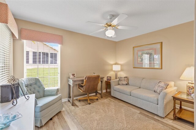 living room with light hardwood / wood-style flooring and ceiling fan