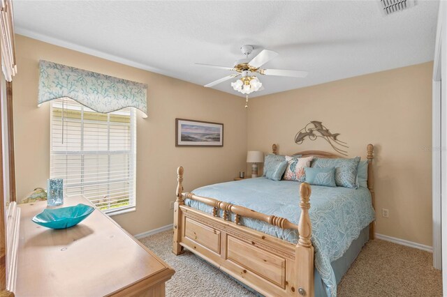 carpeted bedroom featuring a textured ceiling and ceiling fan