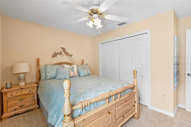 bedroom featuring light carpet, ceiling fan, and a closet