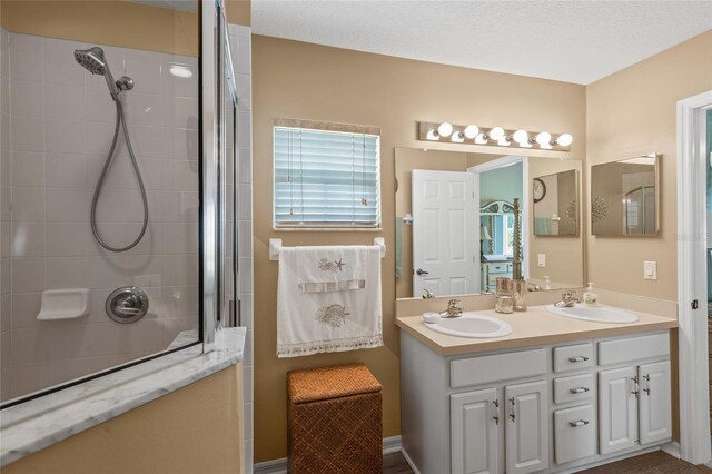 bathroom with double vanity and a shower with shower door