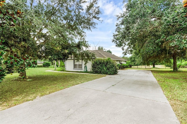 view of property hidden behind natural elements featuring a front lawn