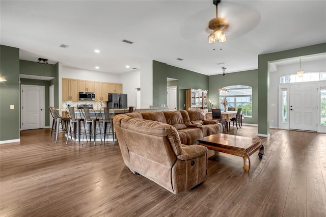 living room with ceiling fan and dark wood-type flooring