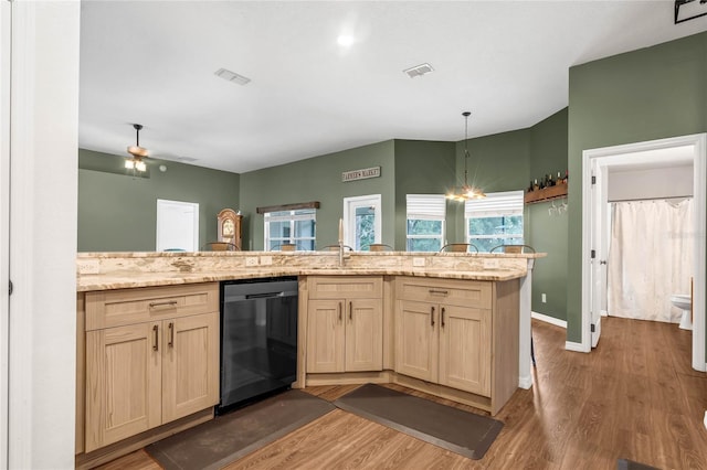 kitchen with sink, kitchen peninsula, black dishwasher, and wood-type flooring