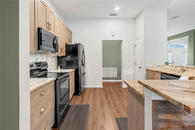 kitchen with light brown cabinetry, backsplash, black appliances, and light wood-type flooring