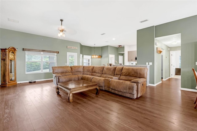 living room featuring wood-type flooring and a notable chandelier