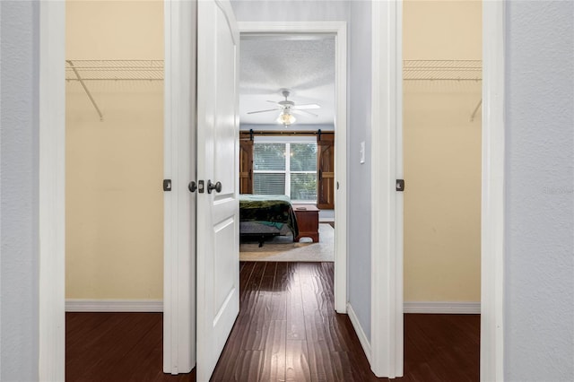 hallway featuring a textured ceiling and dark hardwood / wood-style flooring