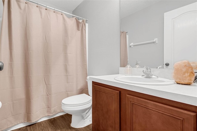 bathroom with hardwood / wood-style floors, toilet, and vanity