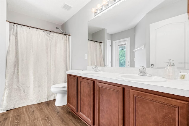 bathroom featuring wood-type flooring, toilet, and vanity