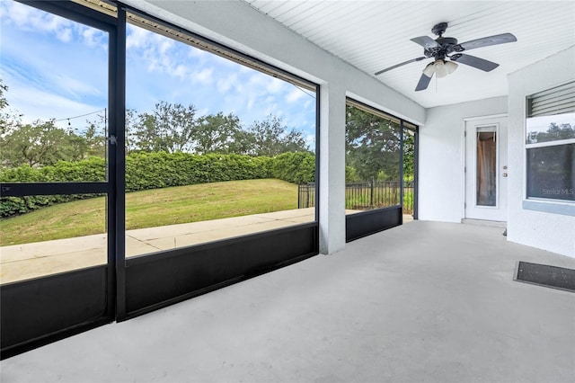 unfurnished sunroom with ceiling fan