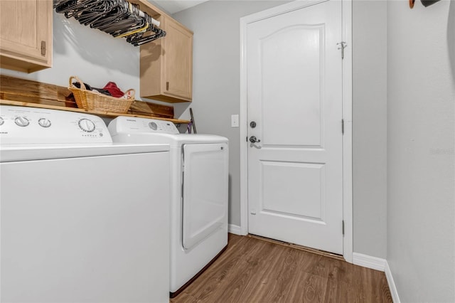 laundry area with cabinets, separate washer and dryer, and light hardwood / wood-style floors