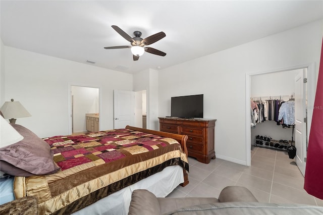 tiled bedroom with a closet, connected bathroom, ceiling fan, and a spacious closet