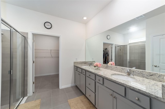 bathroom featuring dual vanity, tile patterned flooring, and an enclosed shower