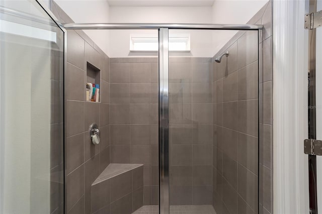 bathroom with a shower with door