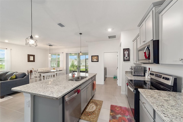 kitchen with gray cabinets, appliances with stainless steel finishes, and a wealth of natural light