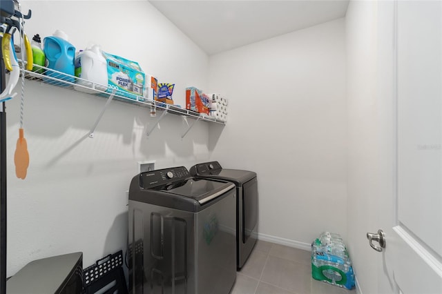 laundry area with independent washer and dryer and light tile patterned floors