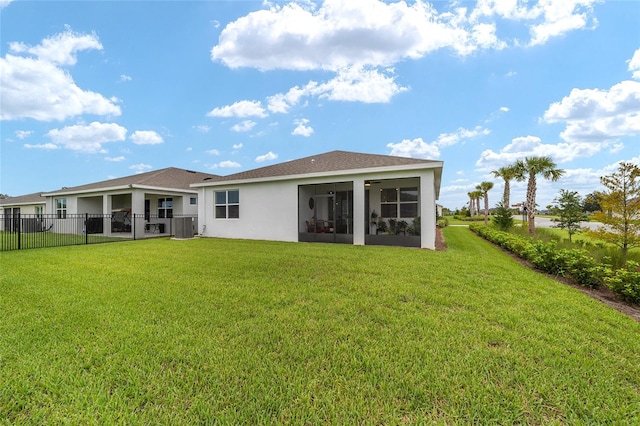 rear view of property featuring a sunroom and a yard