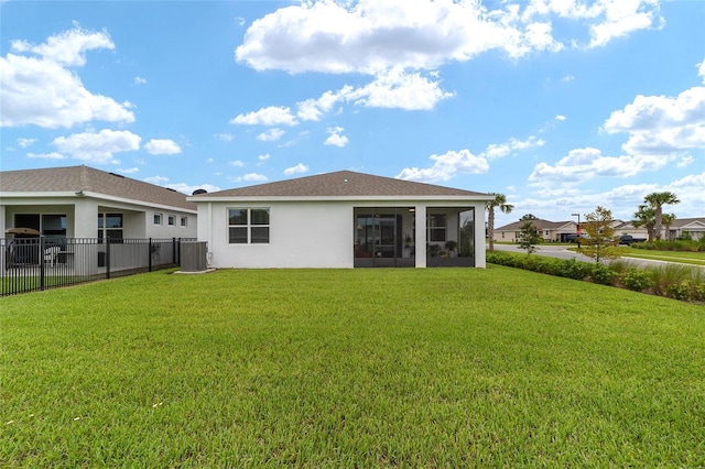 rear view of property with central air condition unit and a lawn