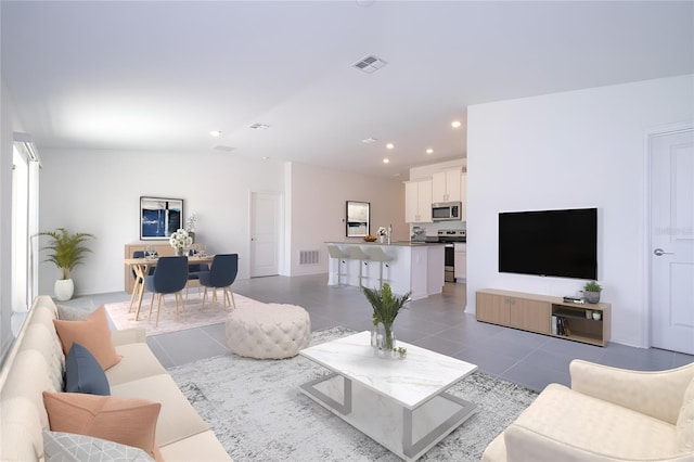 living room with lofted ceiling and light tile patterned floors