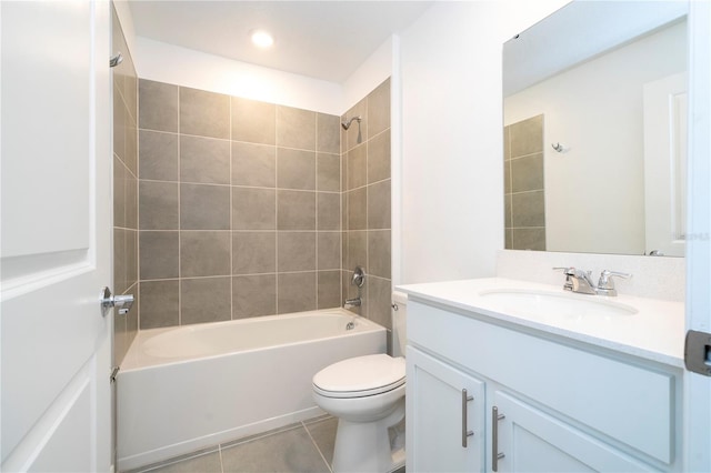 full bathroom with tile patterned flooring, vanity, tiled shower / bath combo, and toilet