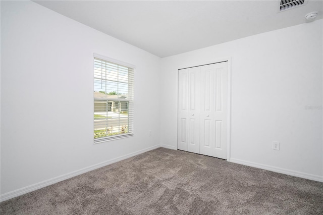 unfurnished bedroom with carpet floors and a closet